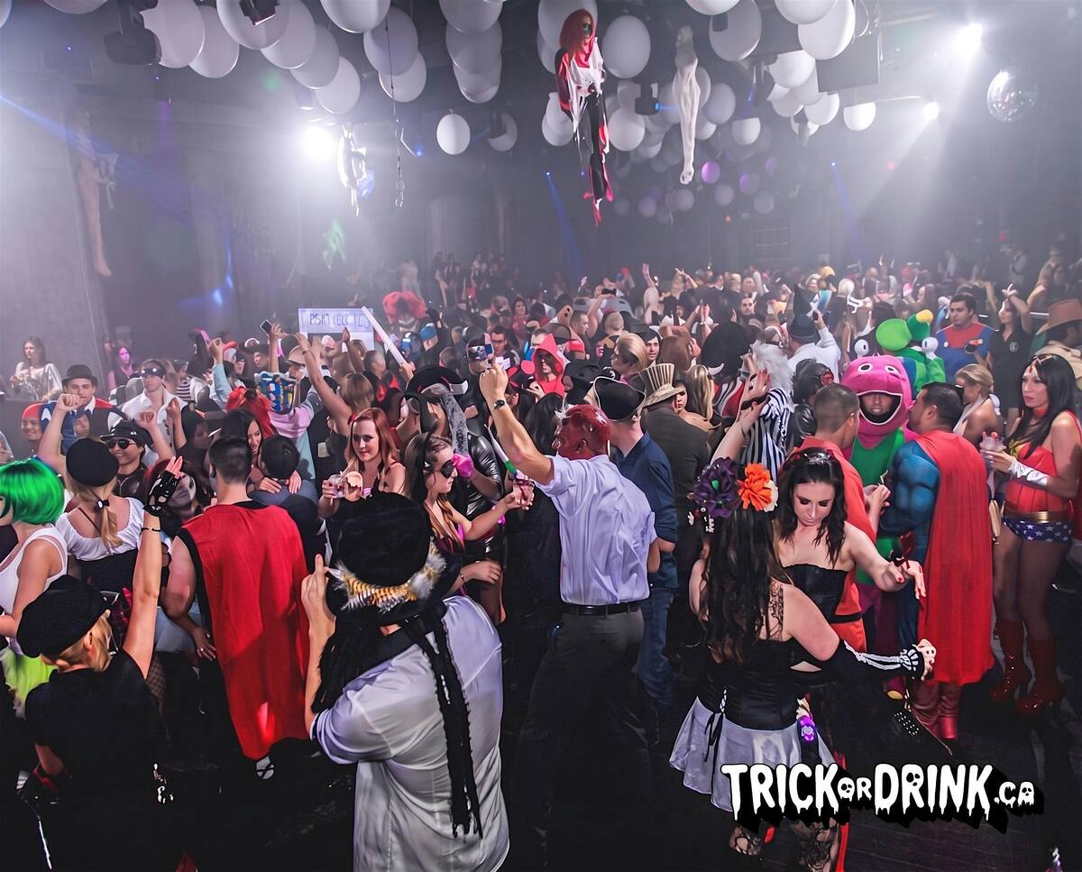 A packed Halloween crawl finale under a ceiling of balloons